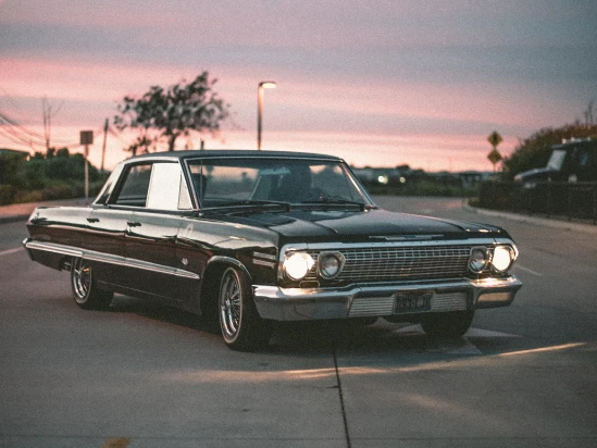 Black classic car parked at sunset
